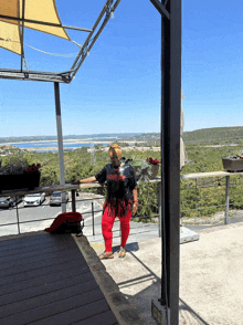 a woman standing on a balcony wearing a t-shirt that says guns n ' roses