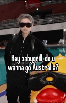 a person wearing sunglasses is standing next to an inflatable duck and says hey babygrill do u wanna go australia ?