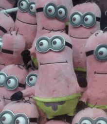 a bunch of stuffed pink minions with big eyes