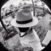 a black and white photo of a man wearing a hat and a shirt that says ' chanel ' on it