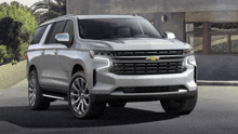 a silver chevrolet suv parked in front of a building