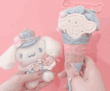 a person is holding a stuffed animal and a ice cream cone with a cinnamoroll on it .