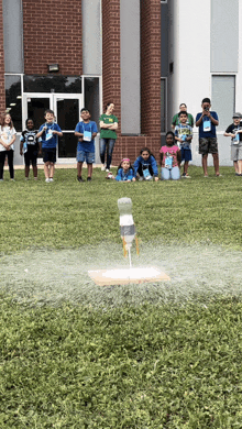 a group of kids are watching a bottle rocket launch