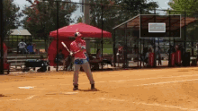 a baseball player wearing a red white and blue shirt with the letter l on it is swinging a bat