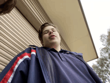 a young man wearing a polo shirt with a red white and blue stripe