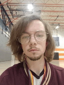 a young man wearing glasses and ear buds takes a selfie