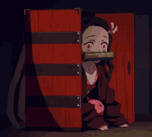 a little girl with a bamboo pipe in her mouth is peeking out from behind a red box