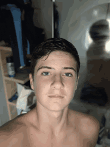 a young man without a shirt is taking a selfie