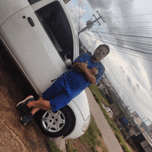 a man giving a thumbs up while standing next to a white car