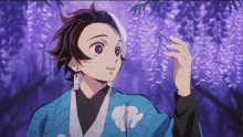 a boy in a blue kimono stands in front of a purple flower