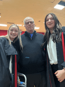 a man and two girls posing for a picture in a gym