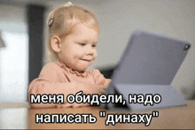 a little girl sitting at a table looking at a tablet with foreign writing on it