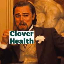 a man in a suit holding a sign that says clover health