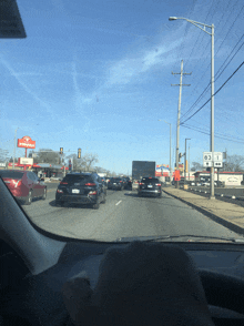 a car is driving down a highway with a donut shop in the background