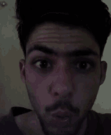 a man with a beard is looking at the camera with his mouth open