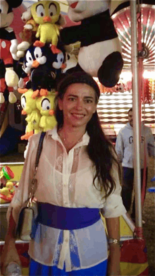 a woman stands in front of a display of stuffed animals including mickey mouse and looney tunes