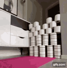 a bunch of toilet paper stacked on top of each other on a pink mat