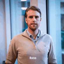 a man wearing a gray sweater with the word ratio written below him