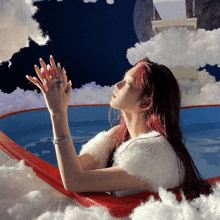 a woman with long red nails is sitting in a bathtub surrounded by clouds