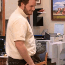 a man in a white shirt and tie is standing in front of a printer and a picture of a playground