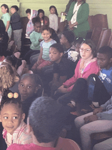 a group of children are sitting in chairs and one of them is wearing a shirt that says ' a ' on the front