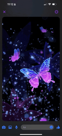 a phone screen shows a picture of butterflies with the time 11:12