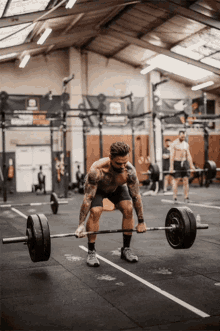 a man is lifting a barbell in a gym with a sign on the wall that says ' gym ' on it