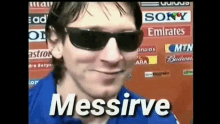 a man wearing sunglasses and a blue shirt with the words messirve on the bottom