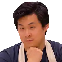 a man wearing a blue shirt and an apron holds his hand to his chin