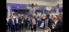 a man in a hat is being lifted in the air by a group of people