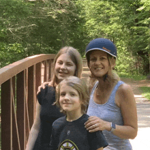 a woman wearing a blue helmet stands next to a boy and a girl