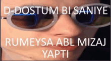 a close up of a person wearing sunglasses with rumeysa abl mizaj yapti written on it