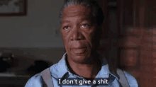 a man in a blue shirt and suspenders is saying `` i don 't give a shit '' in a movie .