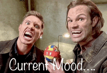 two men are making funny faces in front of a sign that says " current mood "