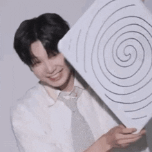 a man is holding a piece of paper with a spiral on it .