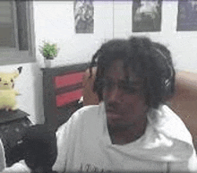 a man with dreadlocks is wearing headphones and sitting in a chair .