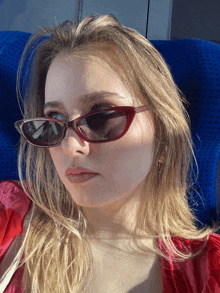 a woman wearing a pair of red sunglasses with the word chanel on them