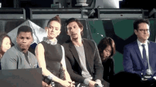 a group of people are sitting in a stadium watching a presentation .