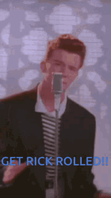 a man singing into a microphone with the words get rick rolled