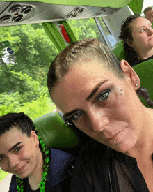 a woman with piercings on her face is sitting in a bus