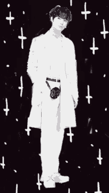 a black and white photo of a man in a white coat with a camera on his belt