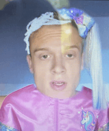 a man in a pink unicorn costume with a blue bow on his head