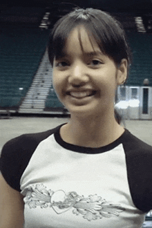 a young girl wearing a black and white shirt is smiling