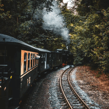 a train is going down the tracks with smoke coming out of the engine