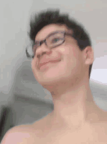 a shirtless man wearing glasses is smiling and making a face .