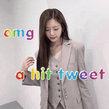 a woman in a suit is standing in front of a wall with the words omg a hit tweet above her