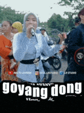 a woman singing into a microphone with the words goyang dong written on the bottom