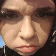 a close up of a woman 's face with a nose ring on it