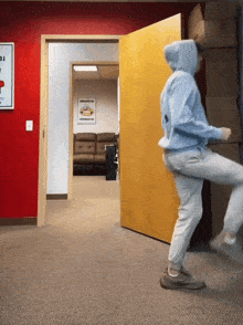 a man in a blue hoodie is standing in a hallway with a sign on the wall that says iowa on it