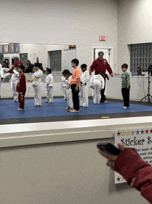 a group of kids are practicing martial arts in front of a mirror